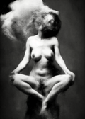 Black and white artistic photograph of a nude female figure in a seated meditative pose with smoke or powder around her head and body, set against a dark studio background.  Unmoored series.
