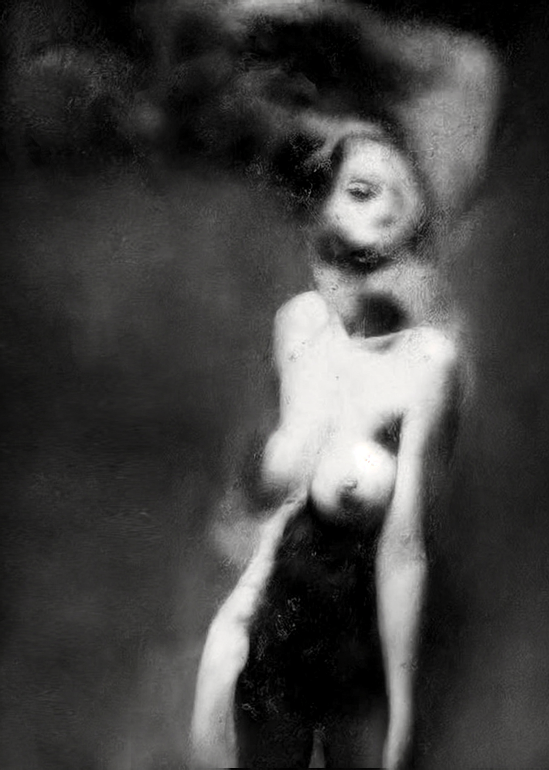 Black and white artistic photograph of a nude female figure in a seated meditative pose with smoke or powder around her head and body, set against a dark studio background.  Unmoored series.