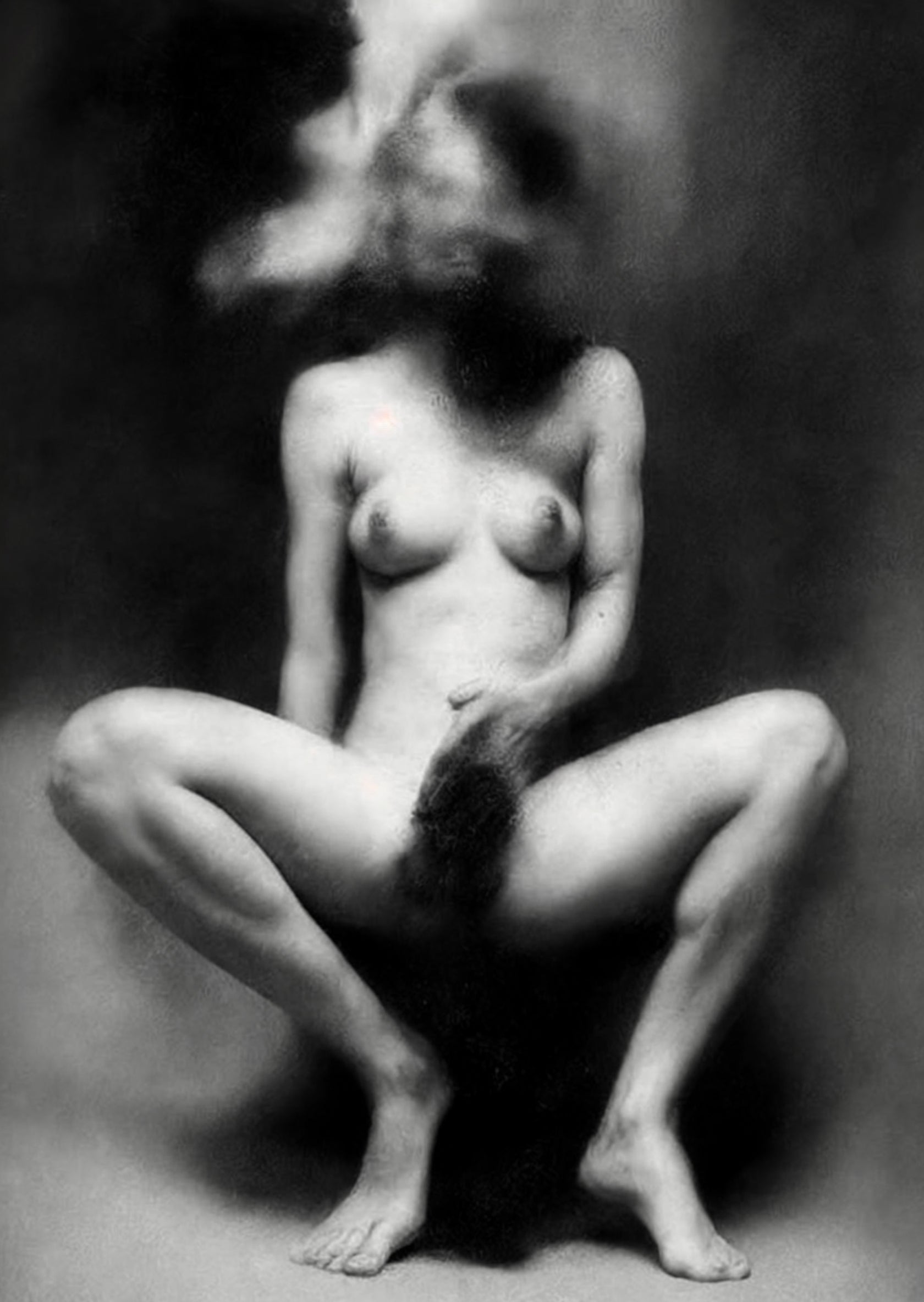 Black and white fine art photograph of a nude female figure standing against a dark textured background, with her head rendered as a surreal melting mass of hair, skin, and abstract forms.  Unmoored series.