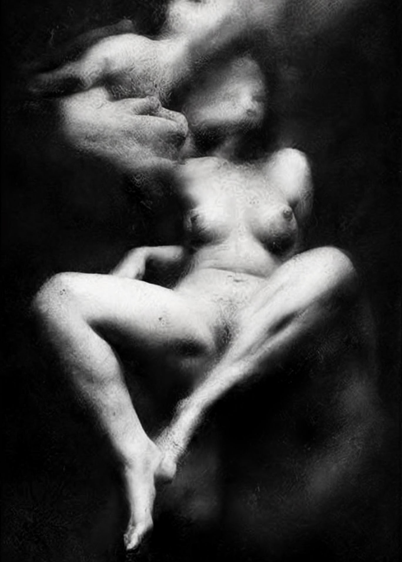 Black and white fine art photograph of a nude female figure in a seated pose, rendered with soft focus and high contrast against a dark background.  Unmoored series.